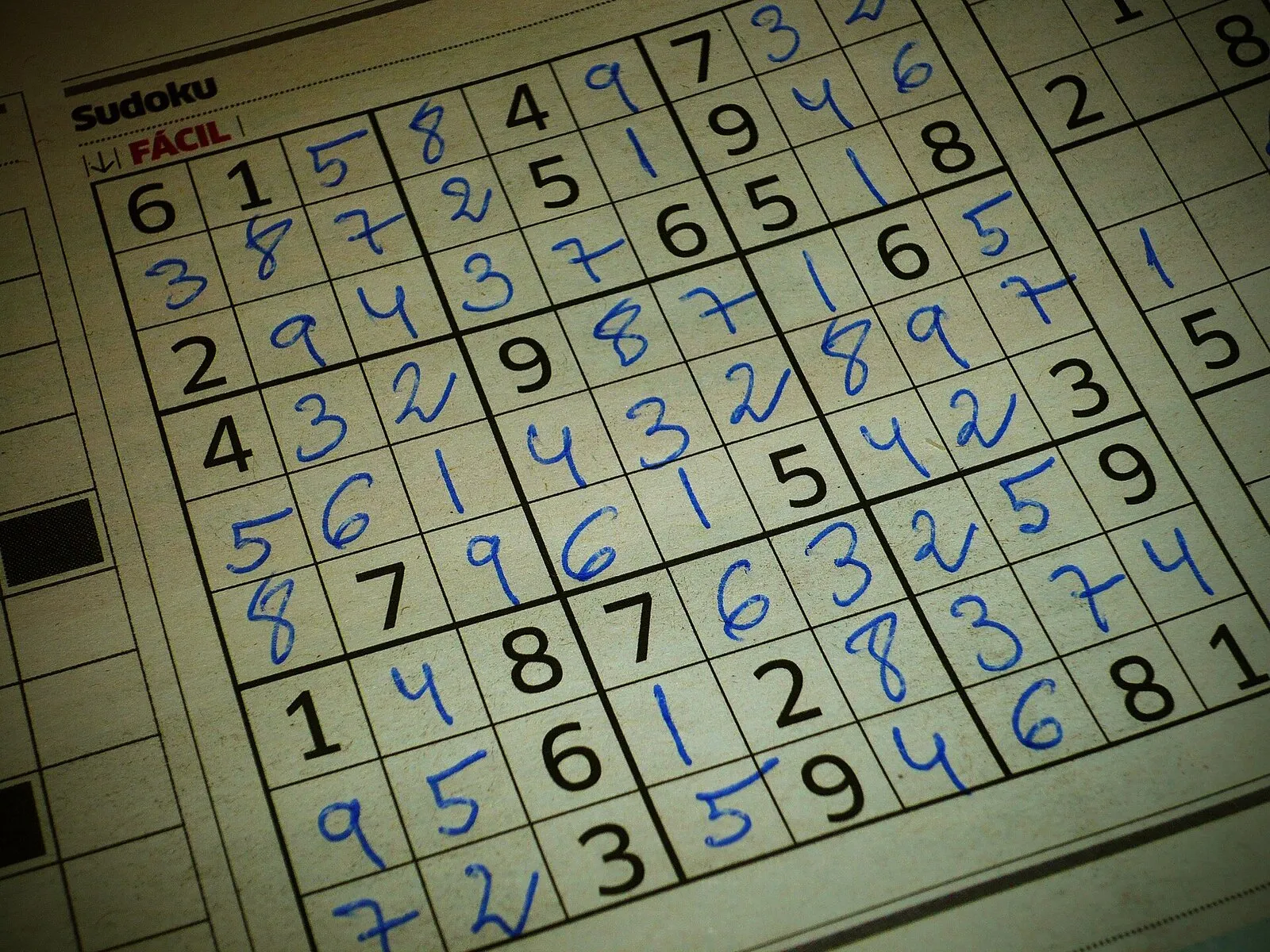 Griglia di sudoku 9x9 stampata su un quotidiano e completata a penna blu